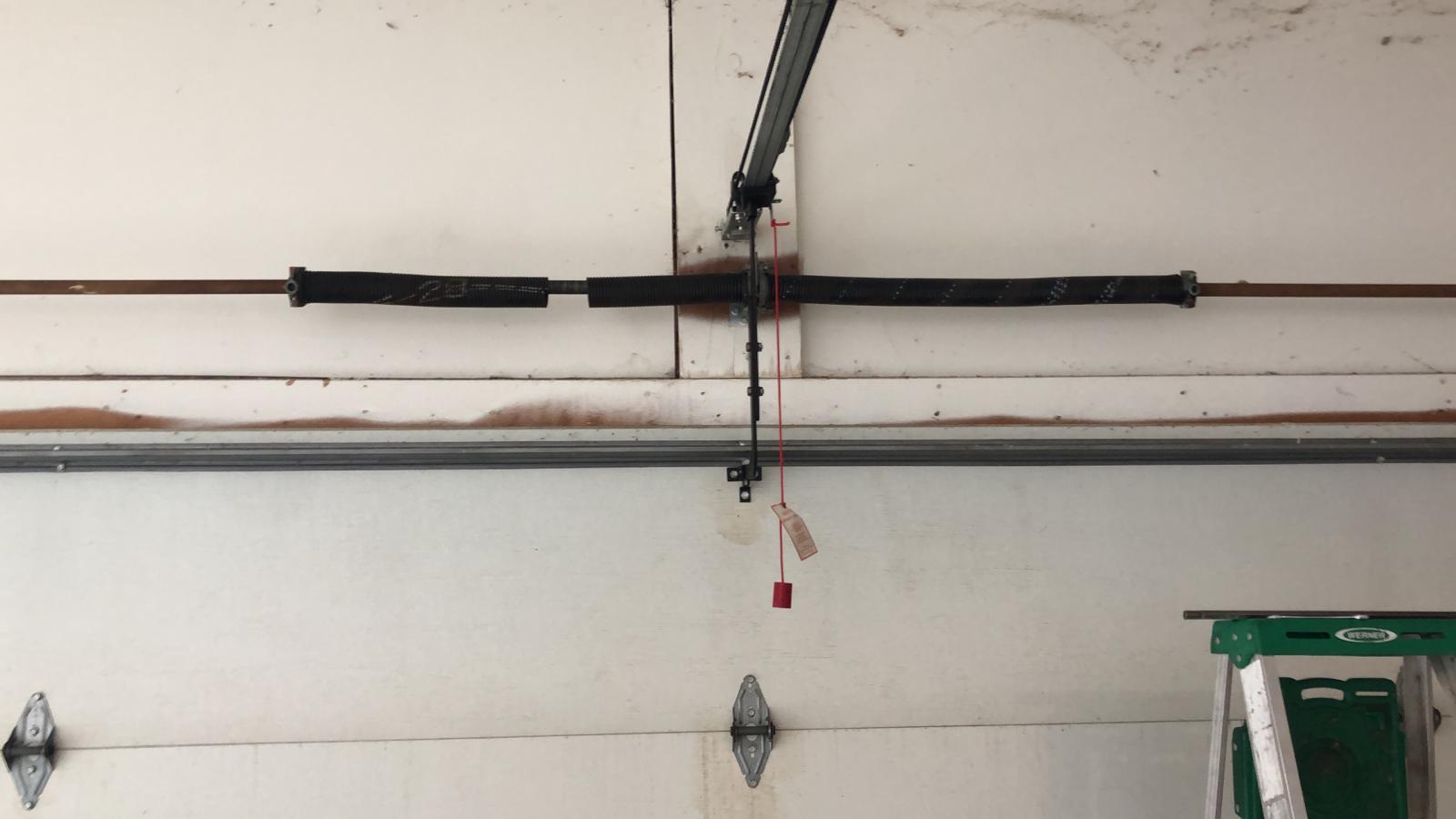 Broken torsion spring before replacement on a Noblesville garage door