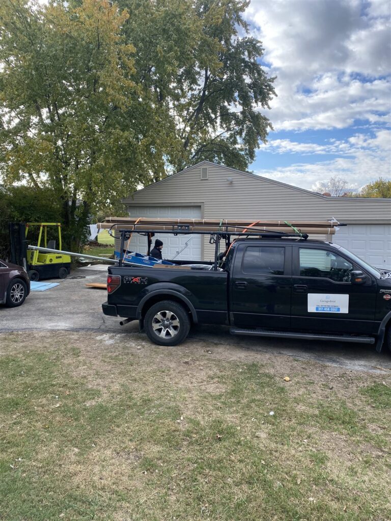 Garage Door Indianapolis black service truck loaded with garage door materials on a job